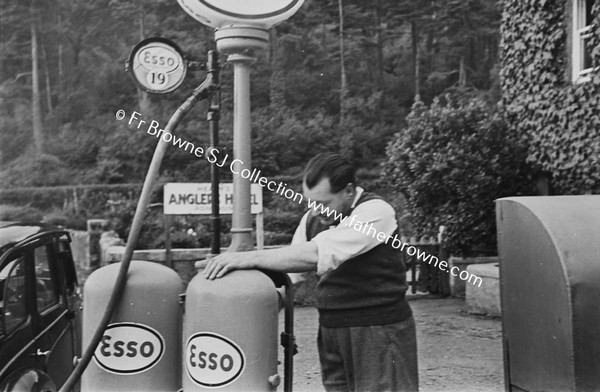 MAN FILLING PETROL AT OLD PUMP